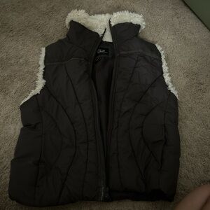 brown puffer vest with white fur around the arms and neck